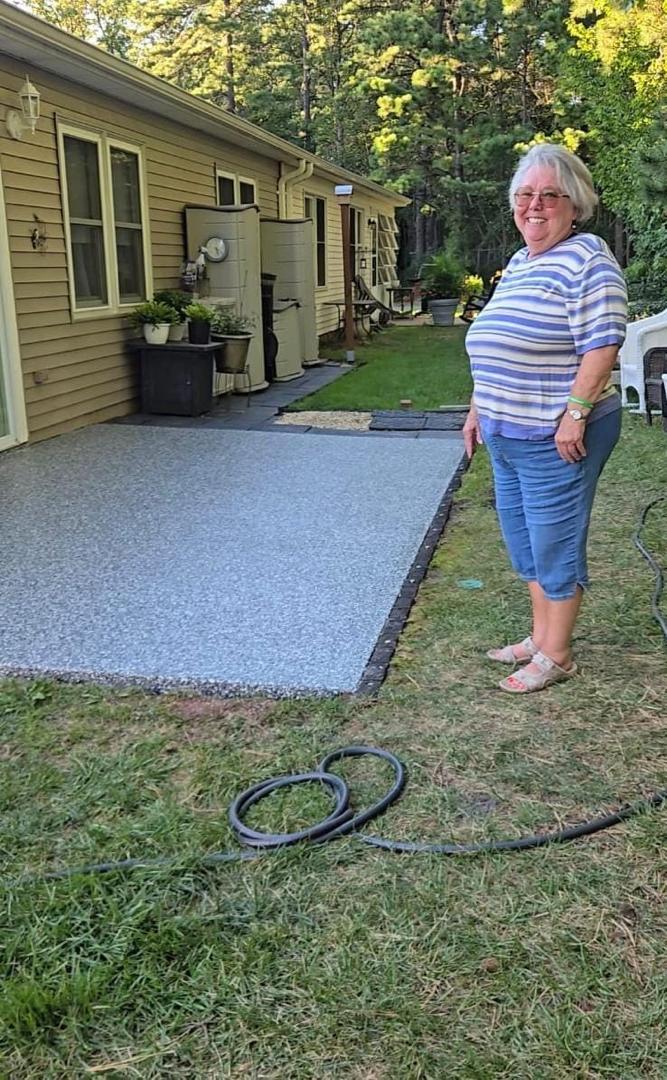 Cindy Wilkins Callano beside her finished epoxy patio in Lakewood, New Jersey